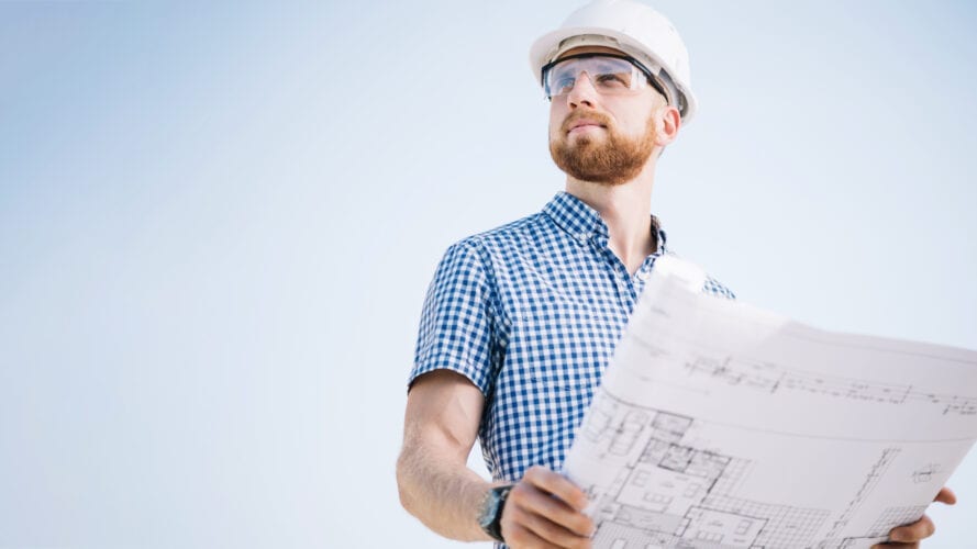Engineer holding schematic drawing in his hands
